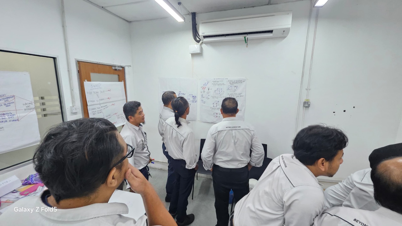Participants reviewing wall notes during Pesaka Nuri training