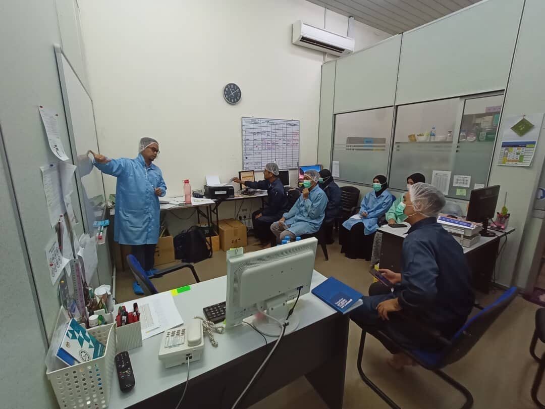 Husni Halim facilitating a lean manufacturing training session in a meeting room